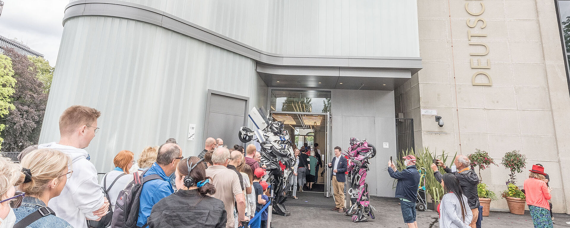 Besucherschlange am Eingang Eine Schlange aus Menschen steht vor dem Eingang ins Museum und wartet an der Kasse.